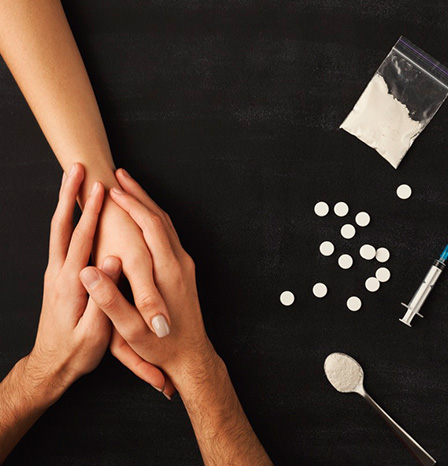 Два человека держатся за руки на фоне наркотических веществ
